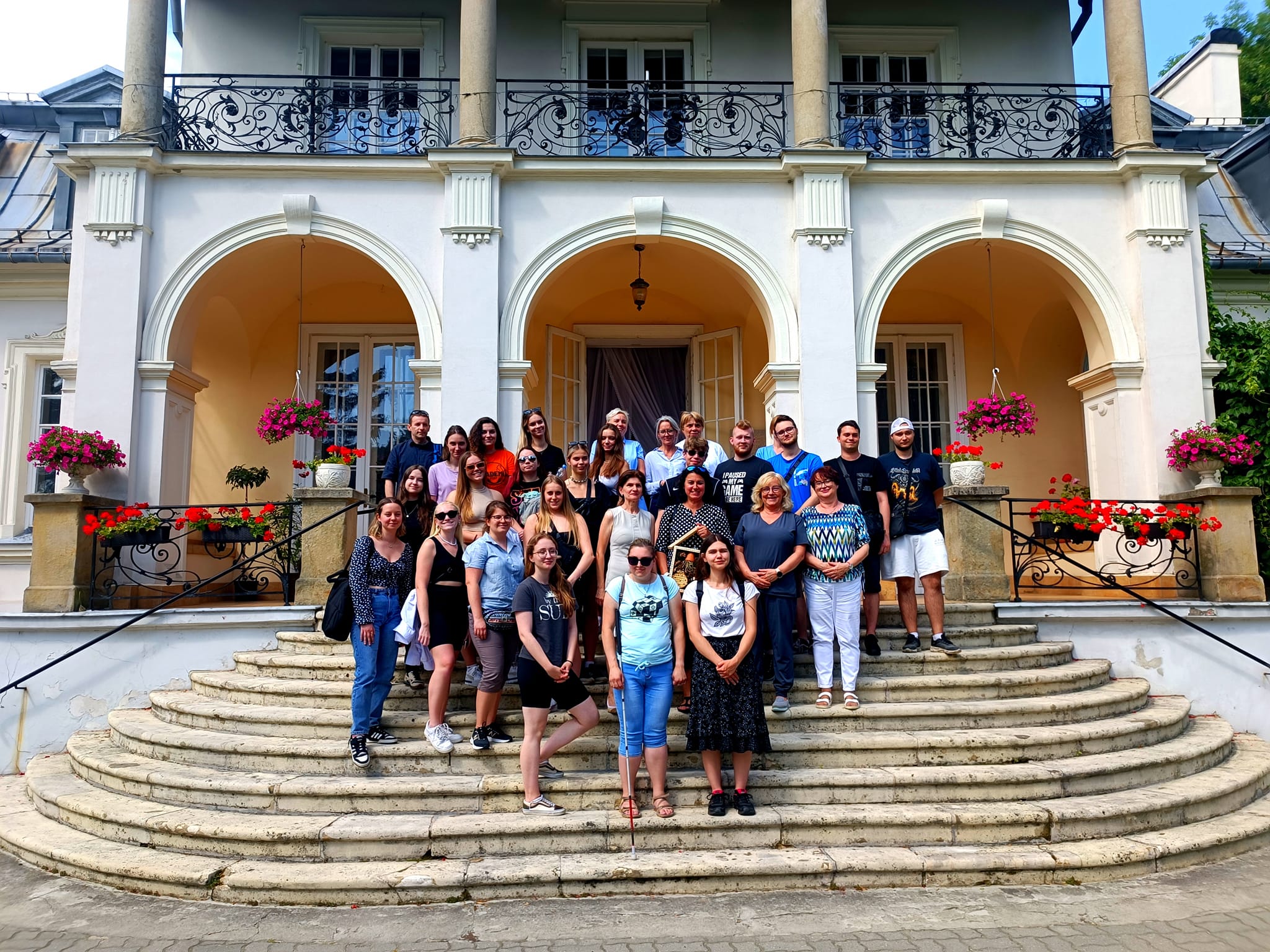 zdjecie uczestników na schodach pałacu